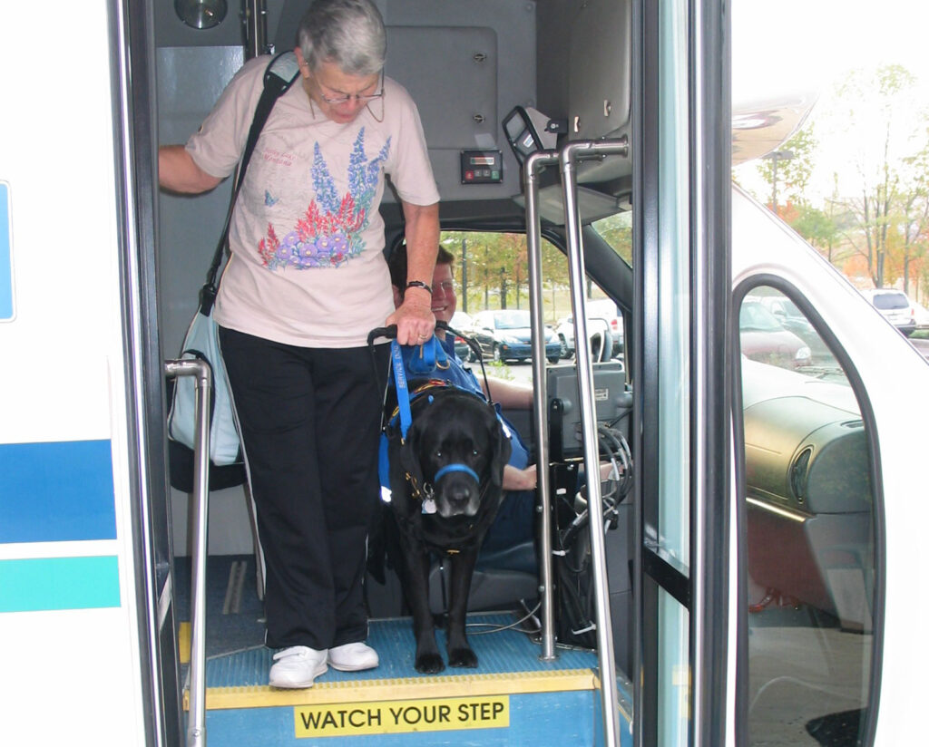 person exiting bus with service dog